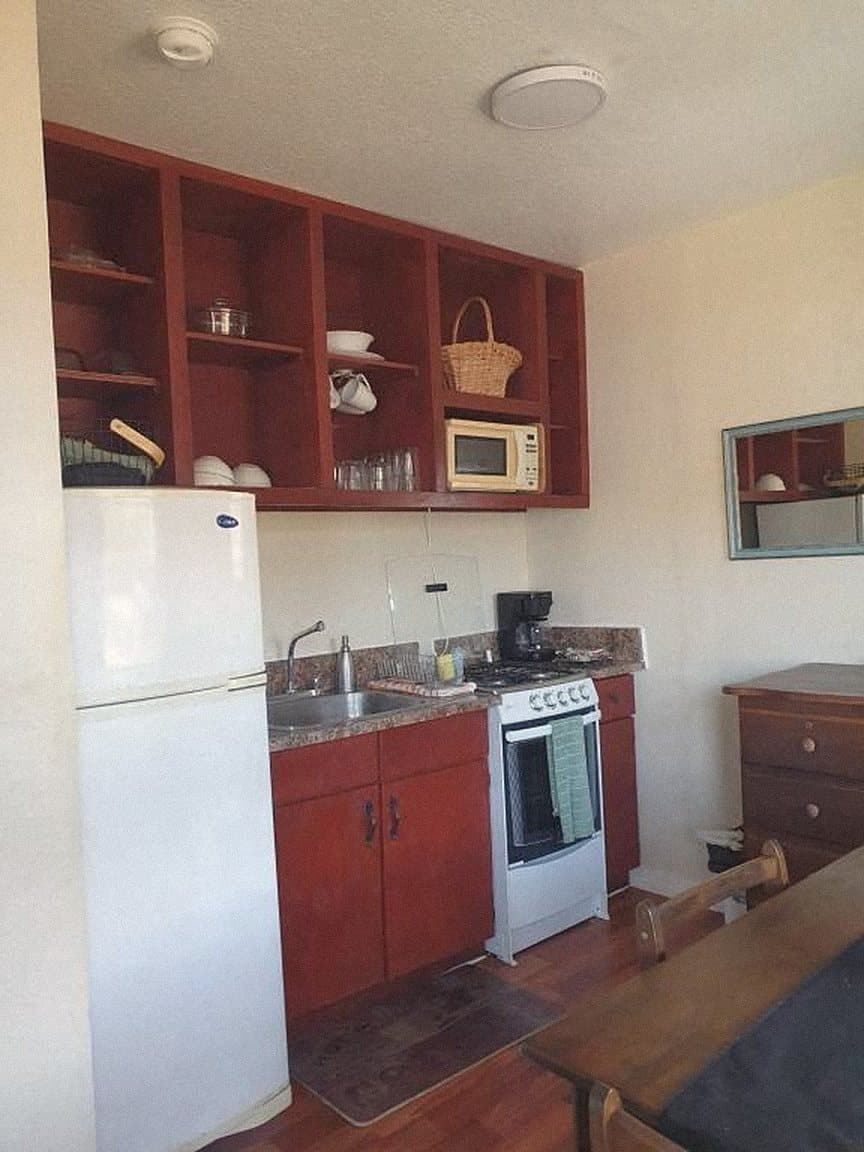 Kitchen with red cabinets and a full-size fridge