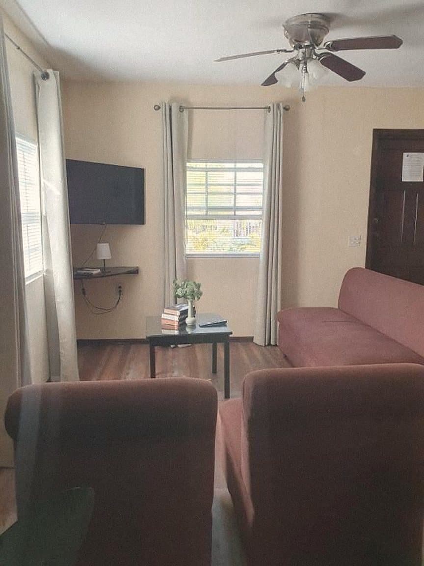 Living room with red sofas and a ceiling fan