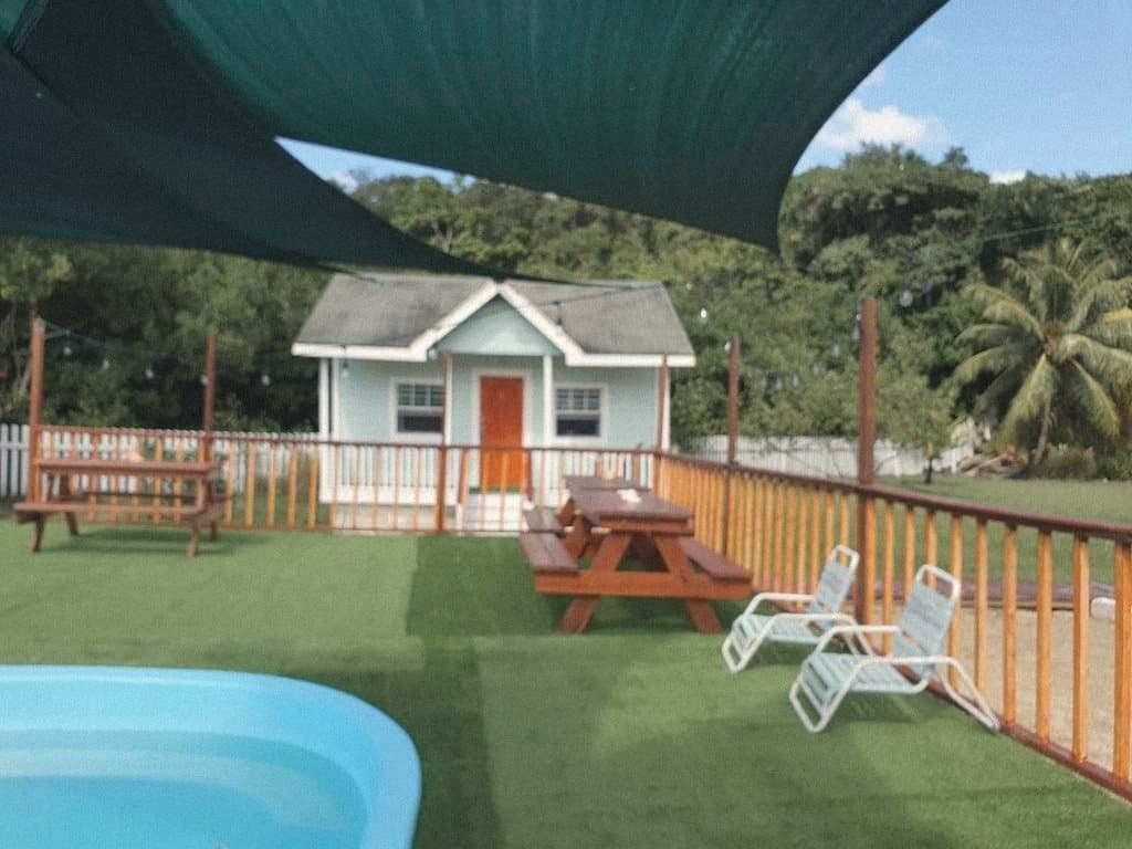 Pool deck with picnic tables under a shade sail